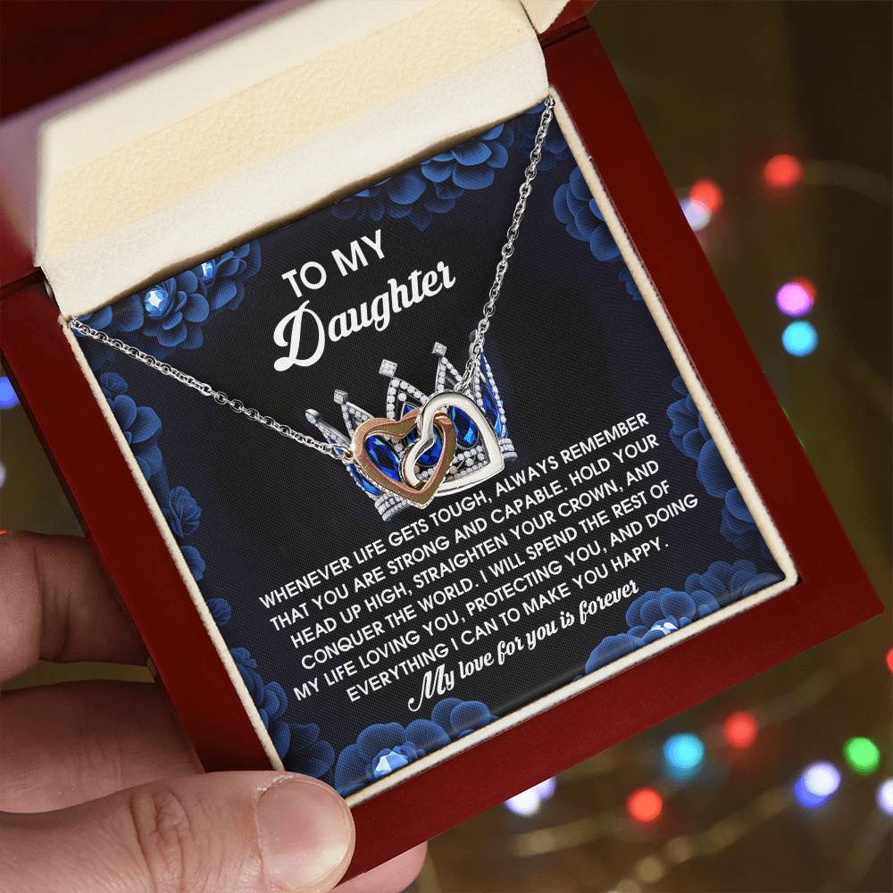 The Daughter-Make You Happy - Interlocking Hearts Necklace, presented in a red box, showcases cubic zirconia crystals and an inspiring card saying "To My Daughter." Made from surgical steel with a rose gold finish, it embodies love, support, and happiness.