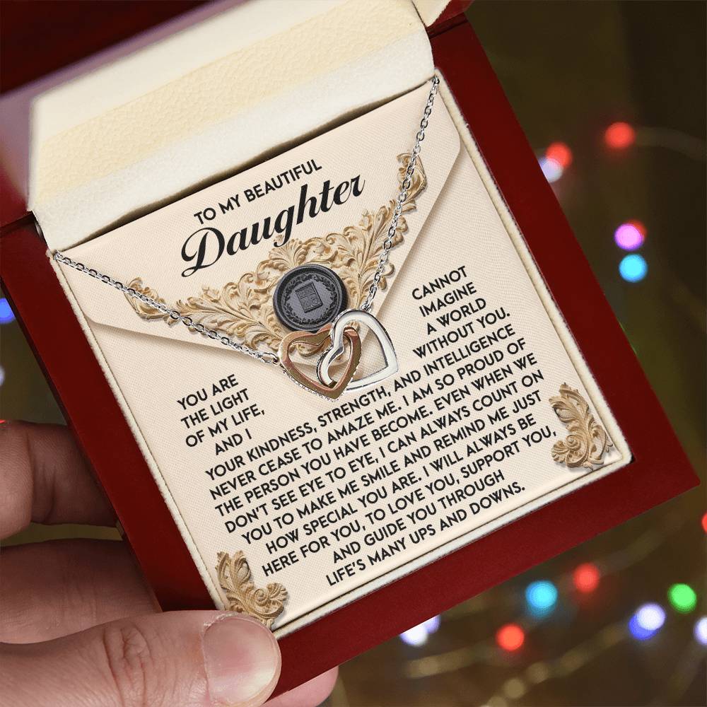 A person opens a jewelry box to reveal the Daughter-Amaze Me - Interlocking Hearts Necklace, adorned with shimmering cubic zirconia crystals and featuring a stunning rose gold finish that beautifully enhances the heartfelt message for a daughter.