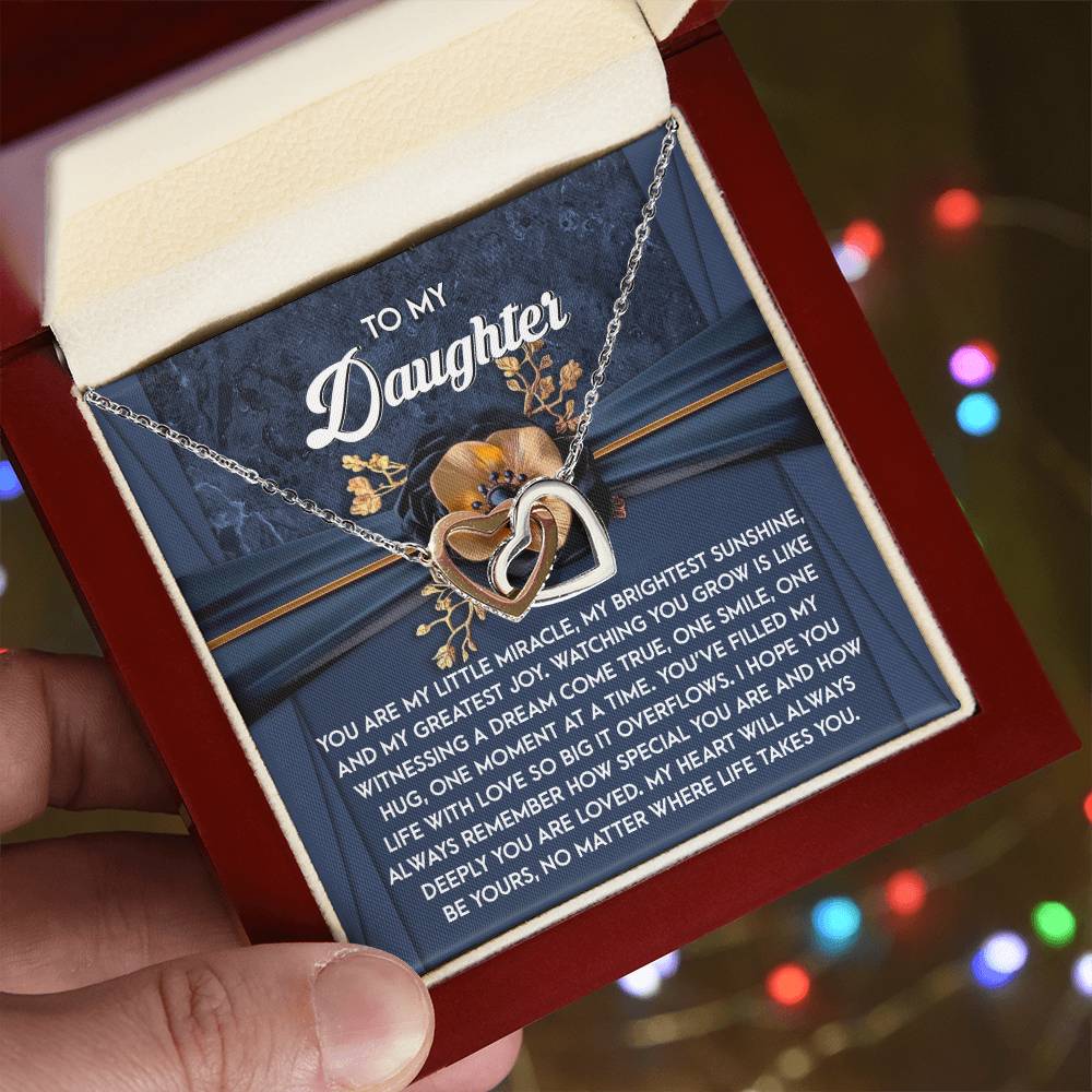 The Daughter-You Are Loved Interlocking Hearts Necklace, adorned with sparkling cubic zirconia crystals, arrives in a gift box featuring a card that reads "To My Daughter" and includes a heartfelt message celebrating your unbreakable bond.