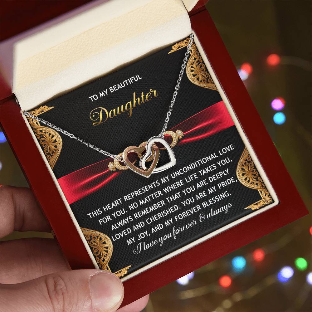 A hand holds an open box displaying the Daughter-Love For You - Interlocking Hearts Necklace, featuring shining cubic zirconia crystals and a heartfelt message to a daughter about unconditional love and pride.