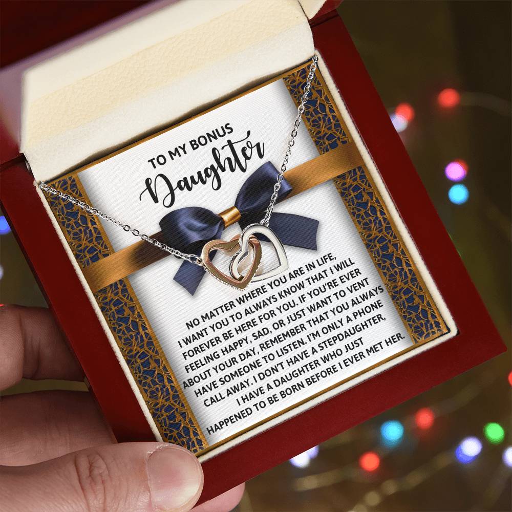 The Daughter-Have Someone Interlocking Hearts Necklace, featuring sparkling cubic zirconia and a rose gold finish, is housed in a box with a heartfelt message for your bonus daughter, expressing endless love and unwavering support.