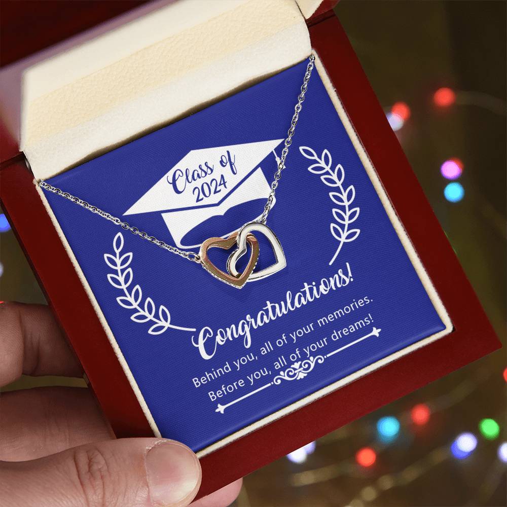 A hand holding a red gift box with a Before You All Your Dreams - Interlocking Hearts Necklace from ShineOn Fulfillment and a message for the class of 2024.