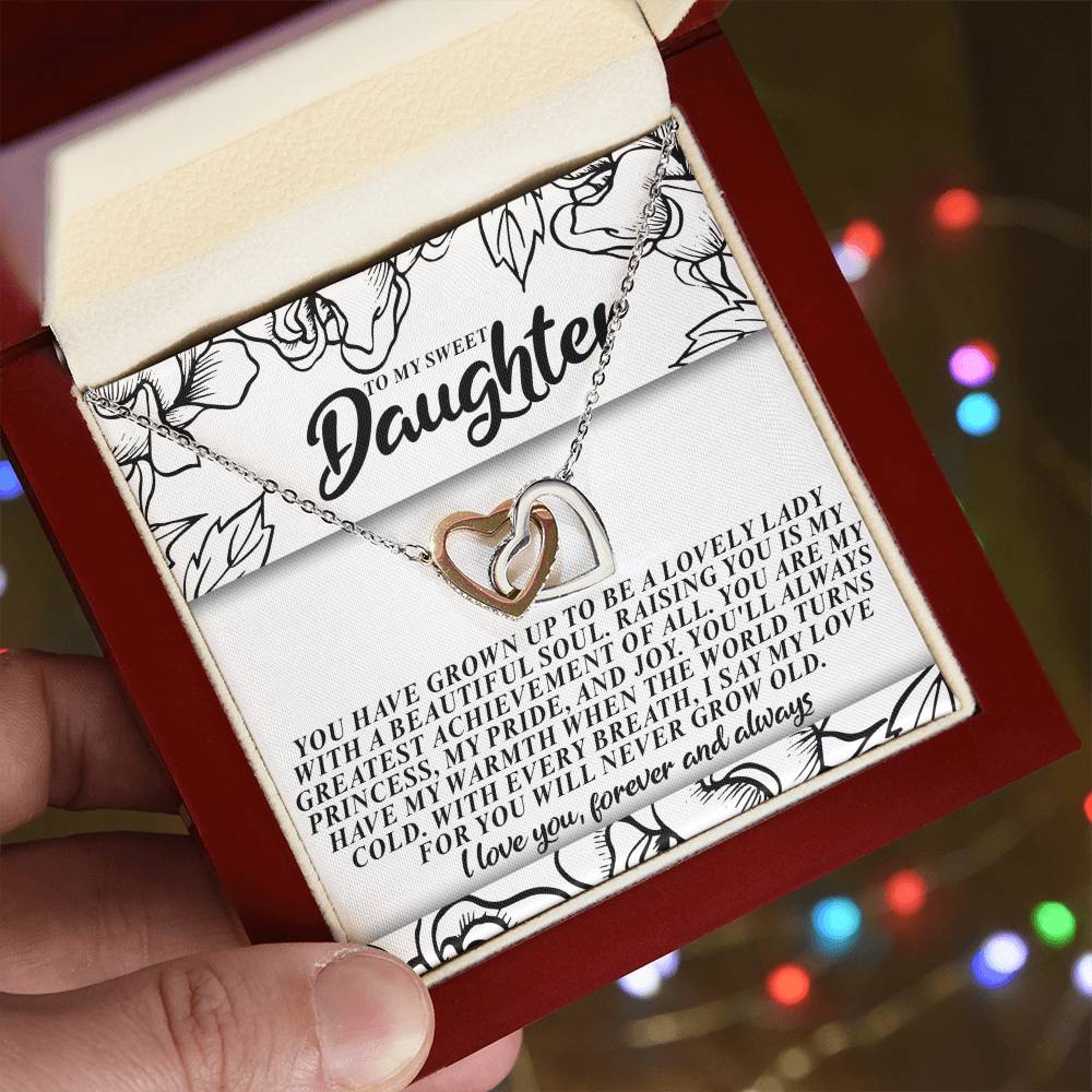 An open red box reveals the Daughter-Beautiful Soul - Interlocking Hearts Necklace in rose gold. The lid displays a heartfelt message on floral-patterned paper to a daughter, expressing love and admiration.