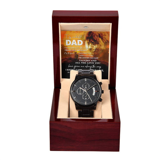 A black chronograph watch with a copper dial is elegantly displayed in an open wooden box. Inside the lid, a partially visible message featuring a lion image and text addressed to "Dad" adds a personal touch to this "To Dad, Repay Your Love - Metal Chronograph Watch".