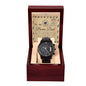 A black chronograph watch called "To Bonus Dad, Heal A Heart - Metal Chronograph Watch" is displayed in an open wooden box. The watch faces an inscribed message on the lid that reads, "To my Bonus Dad" with a heartfelt note underneath.