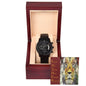 A black To Dad, Respected - Metal Chronograph Watch with a stainless steel bracelet is displayed inside a wooden box. Behind the watch is a card featuring a lion and the word "FATHER" with attributes like Friend, Ally, and Teacher written next to it.