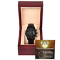 A black chronograph wristwatch presented in an open wooden gift box with a "To Dad, My Guiding Light" message displayed inside the lid.