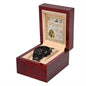 A black To Husband, Great Father - Metal Chronograph Watch with a copper dial is displayed in an open wooden box lined with beige fabric. Behind the watch, an illustrated card with text is positioned upright within the box.