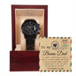 A black chronograph watch called "To Bonus Dad, Heal A Heart - Metal Chronograph Watch" is displayed in an open wooden box. The watch faces an inscribed message on the lid that reads, "To my Bonus Dad" with a heartfelt note underneath.