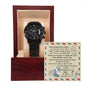 A black To Daddy, Walk Alongside Me - Metal Chronograph Watch is displayed in a wooden box with a message card. The card features a sentimental poem and is designed with an airplane and compass background.
