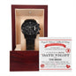 A luxury men's watch, the "To Groom, Date Night - Metal Chronograph Watch," with a black metal strap is displayed in an open wooden box. This elegant timepiece comes with a certificate behind it, featuring the text "DATE NIGHT THE BRIDE.