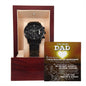 A black chronograph wristwatch presented in an open wooden gift box with a "To Dad, My Guiding Light" message displayed inside the lid.