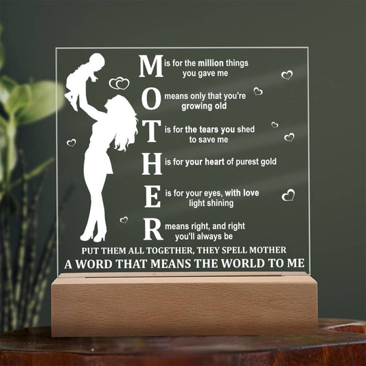 A Mother Acronym Acrylic Plaque with a poem about a mother, featuring a silhouette of a mother and child, displayed on a wooden stand against a plant backdrop—perfect as a Mother's Day gift.