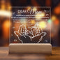 The "To Mom, Your Little One" acrylic plaque with LED features engraved text dedicated to mothers, hands and baby feet outlines, and a wooden base. Perfect for Mother's Day or as a birthday gift from kids, it beautifully captures moments of love and joy.