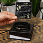 A hand presents an open gift box containing a To Dad, Feel You Around - Love You Forever Bracelet and a father’s day card addressed to a "daddy-to-be" with a heartfelt message.