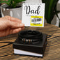 A hand holds a Father's Day card with a reduced price sticker above a To Dad, The Very Best - Love You Forever Bracelet in a gift box.