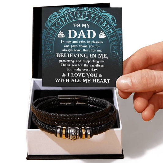 A person's hand holding the To Dad, Pleasure And Pain - Bracelet with metal embellishments, presented in a box with a heartfelt message, "Love You Forever," inscribed on the lid.