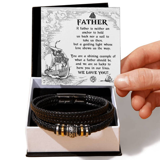 A hand presenting an open gift box containing a To Dad, An Anchor - Love You Forever Bracelet and a greeting card for father’s day with a heartfelt message.