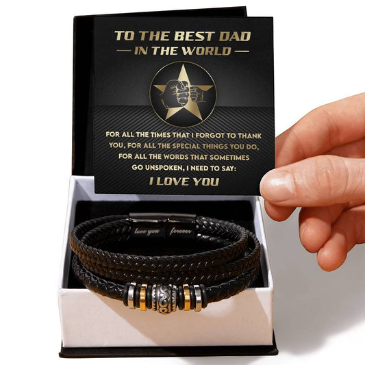 A hand presenting a gift box containing a To Dad, Need To Say - Bracelet with the phrase "Love You Forever" on a metal clasp, next to a card titled "To the Best Dad.