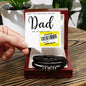 A hand holds a Father's Day card with a reduced price sticker above a To Dad, The Very Best - Love You Forever Bracelet in a gift box.