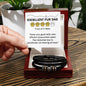 A hand holds a card rating "EXCELLENT FUR DAD: 4 out of 5 Paws." The card praises belly rubs and poop picking but notes a paw deduction for not sharing all food. Below, a To Fur Dad, Sharing All Food - Love You Forever Bracelet completes the picture.