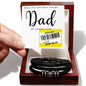 A hand holds a Father's Day card with a reduced price sticker above a To Dad, The Very Best - Love You Forever Bracelet in a gift box.