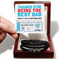 Hands holding a "To Dad, Gift Voucher - Love You Forever Bracelet" above a black vegan leather bracelet with decorative metal accents, in a box.