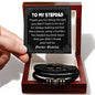A hand holding a card addressed to a stepdad with a message of gratitude. Below the card is the To Stepdad, Will Be Forever - Love You Forever Bracelet, crafted from vegan leather with silver and gold accents, nestled in an elegant box.