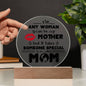 Round To Mom, Someone Special Acrylic Circle Plaque with printed text "any woman can be a mother but it takes someone special to be called mom" and decorative elements including lips and floral patterns, mounted on a wooden LED base.