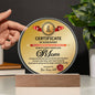 A hand holds the "To Mom, World's Most Marvelous Mom Acrylic Circle Plaque," a heartfelt gift elegantly displayed on a wooden stand, accompanied by a matching certificate of achievement for the "Best Mom Award.