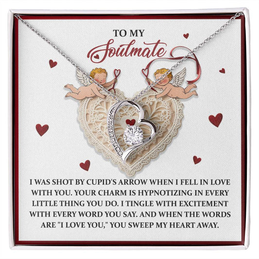 The Soulmate-Sweep My Heart - Forever Love Necklace is a silver heart piece with a diamond, elegantly presented on a display card with romantic inscriptions and cherub illustrations, enhanced by its gold finish and CZ crystal accents for an enchanting touch.