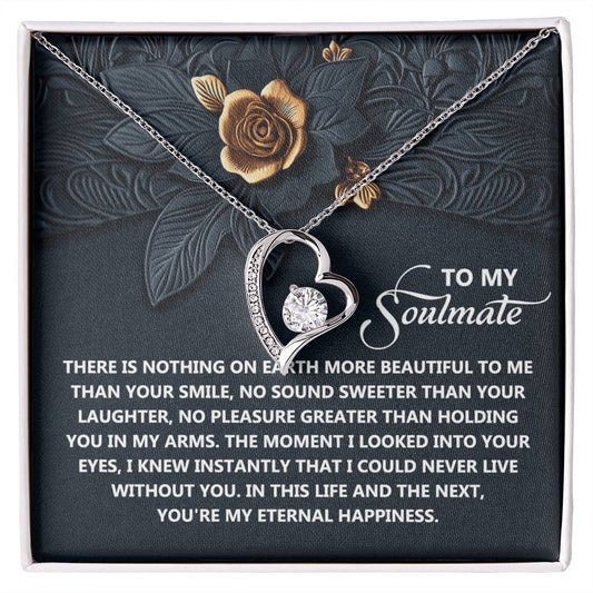 The Soulmate-Eternal Happiness - Forever Love Necklace features a heart pendant on a floral background, inscribed with a romantic message. Adorned with shimmering CZ crystals and finished in white gold, it elegantly captures the essence of eternal love.