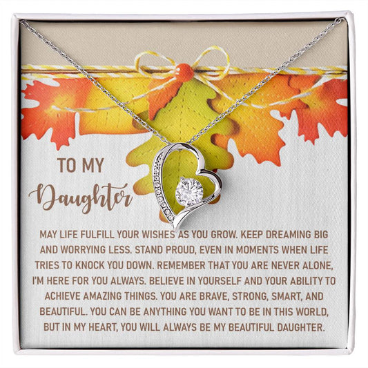The Daughter-For You Always - Forever Love Necklace, featuring a heart shape with a gold finish and diamond accent, is elegantly presented in a box adorned with an autumn leaf design and printed message.