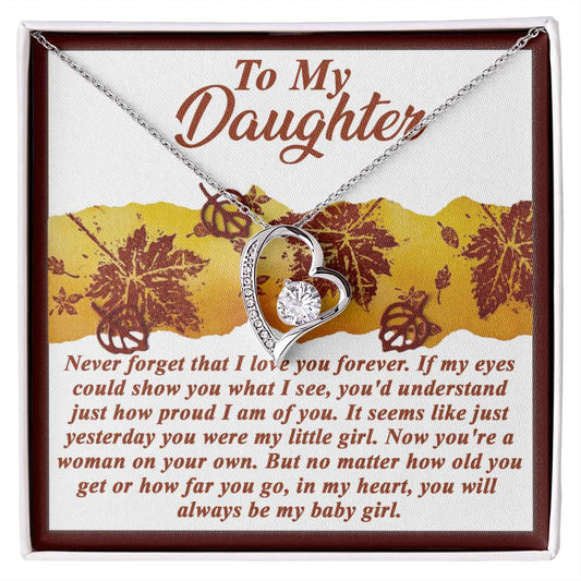 The Daughter-On Your Own - Forever Love Necklace showcases a heart-shaped pendant with an elegant gold finish, embellished with sparkling CZ crystals. It is accompanied by a decorative card featuring a heartfelt message to a daughter, conveying love and pride from her parent.