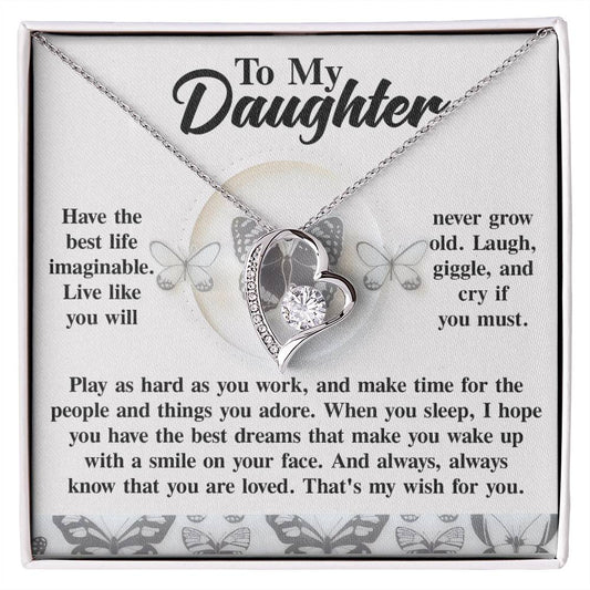 The Daughter-My Wish - Forever Love Necklace, featuring a heart-shaped pendant with a cubic zirconia stone and a gold finish, conveys a heartfelt message to a daughter. It is beautifully presented in a gift box adorned with butterfly designs, perfectly embodying the spirit of the Forever Love Necklace collection.