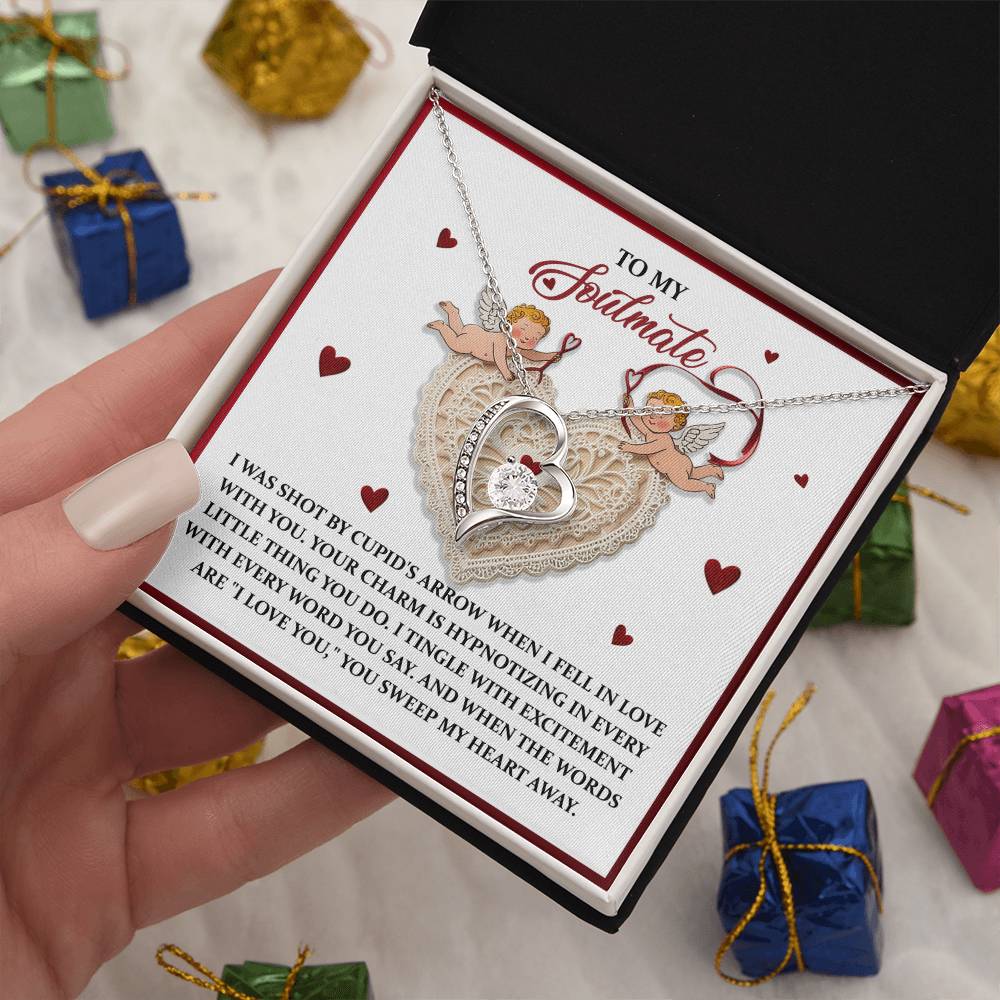 The Soulmate-Sweep My Heart - Forever Love Necklace features a heart shape and CZ crystal, presented in an elegant gold-finished gift box with a romantic message and cherub illustrations inside the lid. Colorful surrounding boxes enhance its sophisticated presentation.