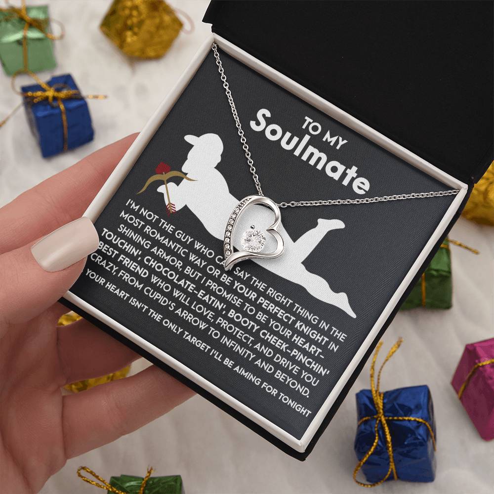 The Soulmate-Cupid's Arrow - Forever Love Necklace features a heart-shaped pendant with a dazzling CZ crystal, elegantly presented in a gift box. The box showcases a silhouette and heartfelt message to your soulmate, all adorned with a white gold finish amidst artfully scattered small wrapped gifts.