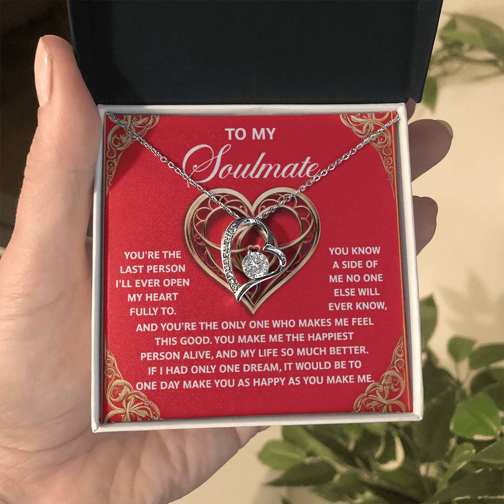 A person holds a box with a Forever Love Necklace inside, featuring intertwined hearts and a central gem with a stunning gold finish. The text on the box reads: "To my Soulmate" along with a romantic message. Product Name: Soulmate-The Only One - Forever Love Necklace.