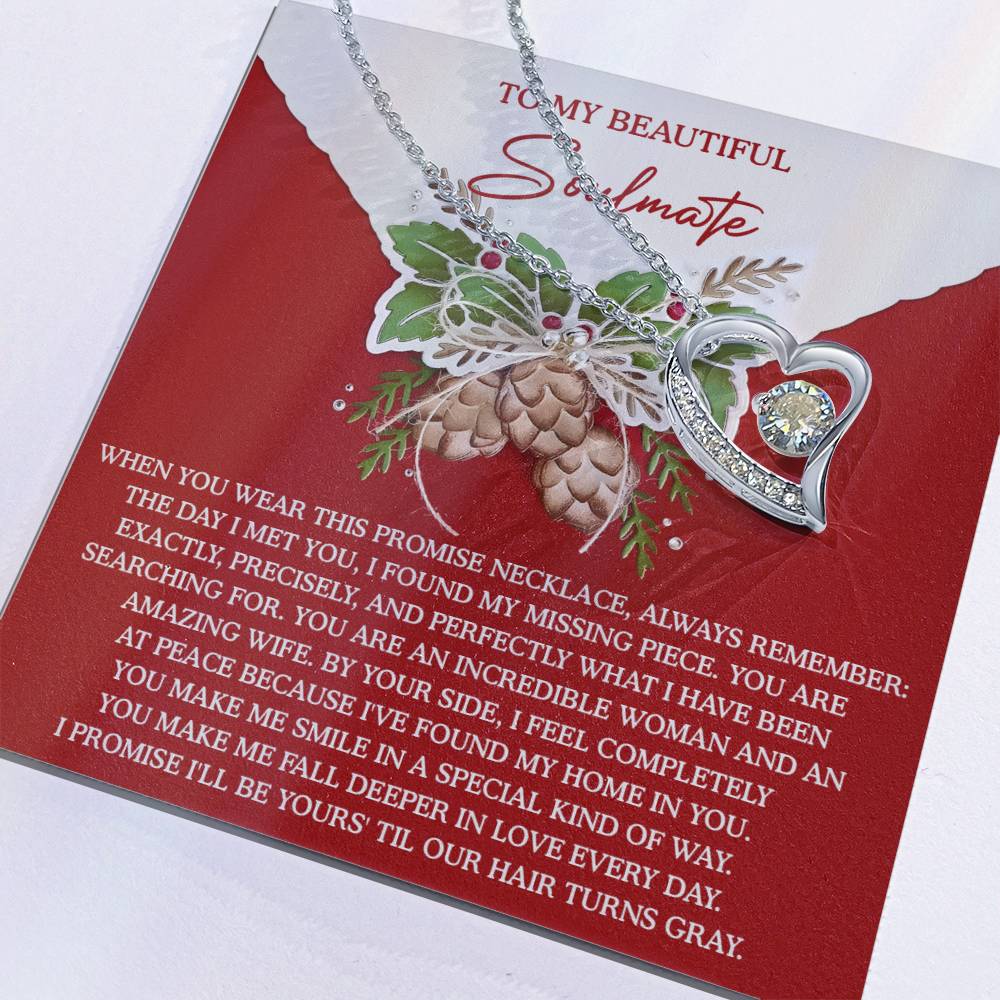 The Soulmate-At Peace - Forever Love Necklace, featuring a CZ crystal pendant, elegantly rests on a card adorned with a romantic message and pinecone decoration.