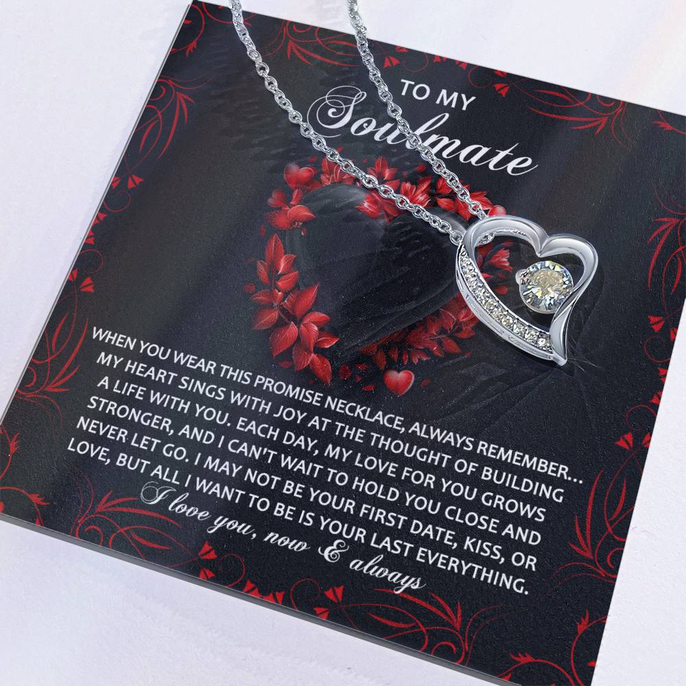 The Soulmate-Hold You Close - Forever Love Necklace features a heart-shaped pendant with a sparkling cubic zirconia. It comes on a card with a romantic love and commitment message, and its red floral design enhances the elegant gold finish.