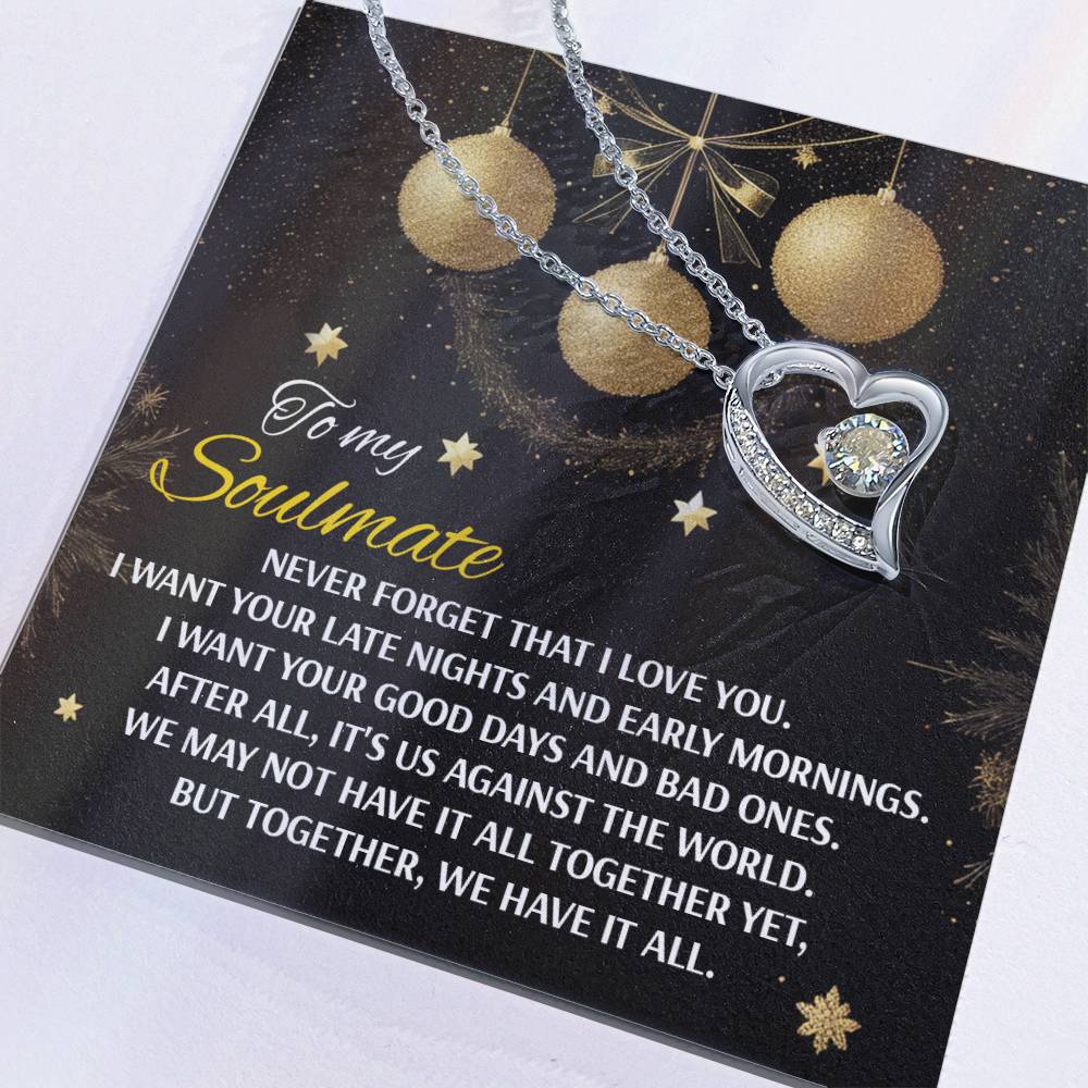 The Soulmate-Have It All - Forever Love Necklace showcases a heart-shaped pendant with a cubic zirconia stone, elegantly presented on a card featuring an affectionate message for a soulmate, and adorned with gold finish accents and delicate snowflakes.