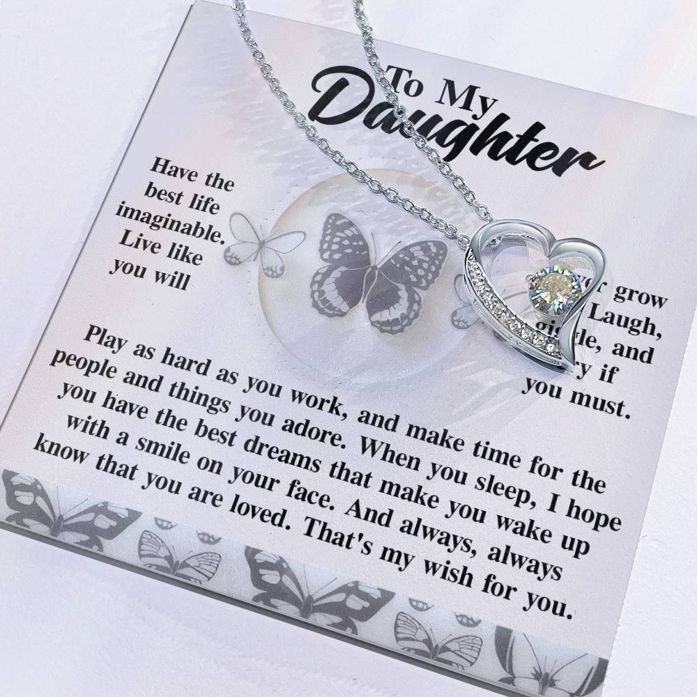 The Daughter-My Wish - Forever Love Necklace, featuring a heart-shaped pendant adorned with a sparkling CZ crystal, is accompanied by a card that says "To My Daughter," embellished with butterfly designs and a heartfelt message.