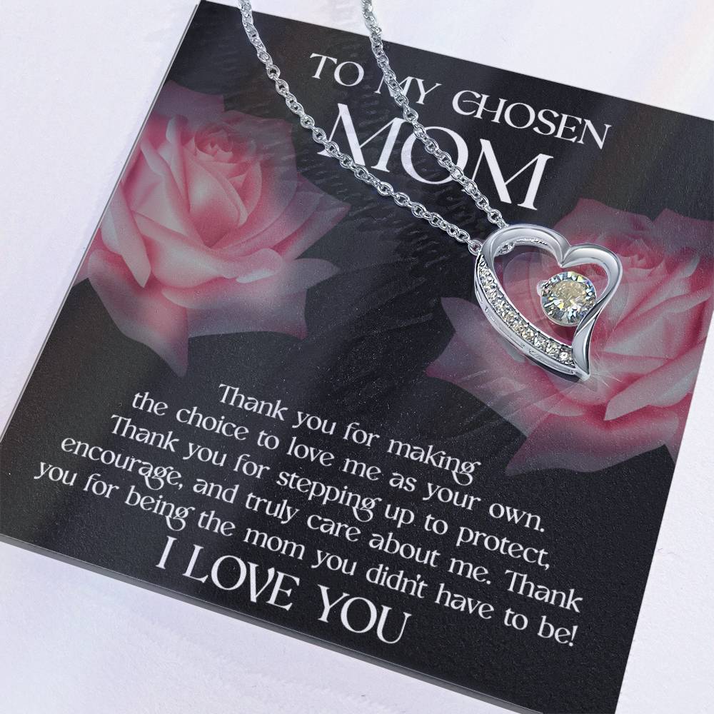 This Mother's Day, express your gratitude with the "To Bonus Mom, My Chosen Mom - Forever Love Necklace." Featuring a heart-shaped pendant with a sparkling stone, this necklace is meticulously laid over a card adorned with roses, symbolizing your appreciation for her unwavering love and support. Available in either a white gold or yellow gold finish.
