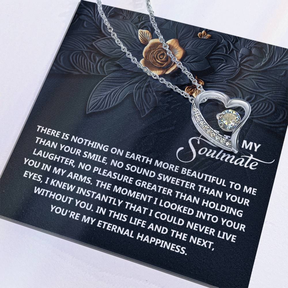 The Soulmate-Eternal Happiness - Forever Love Necklace features a CZ crystal on a card with romantic messages and floral designs. Its heart-shaped charm and white gold finish make it an enduring symbol of affection.