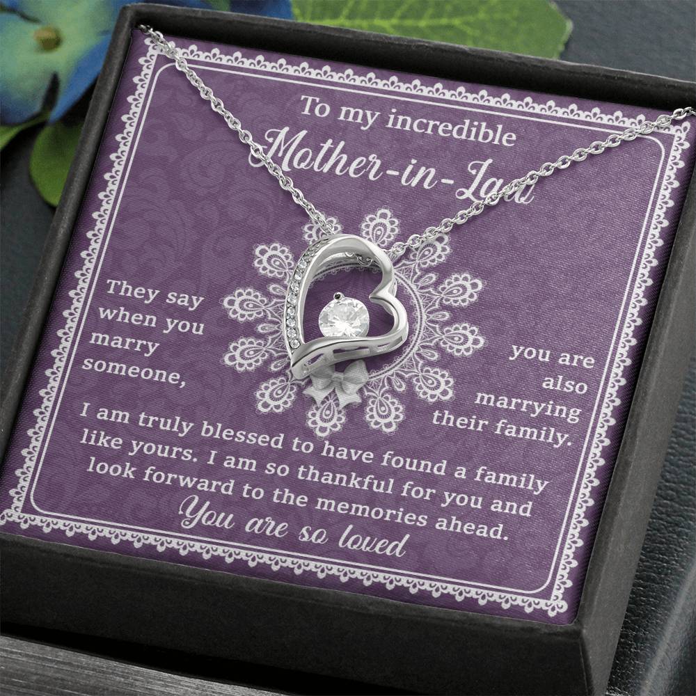 The "To Mother-In-Law, Family Like Yours - Forever Love Necklace" with a 14k white gold finish features a heart pendant displayed in a gift box on a purple floral background, accompanied by a heartfelt message expressing your gratitude and love. This unique gift is perfect for showing your appreciation to your mother-in-law.