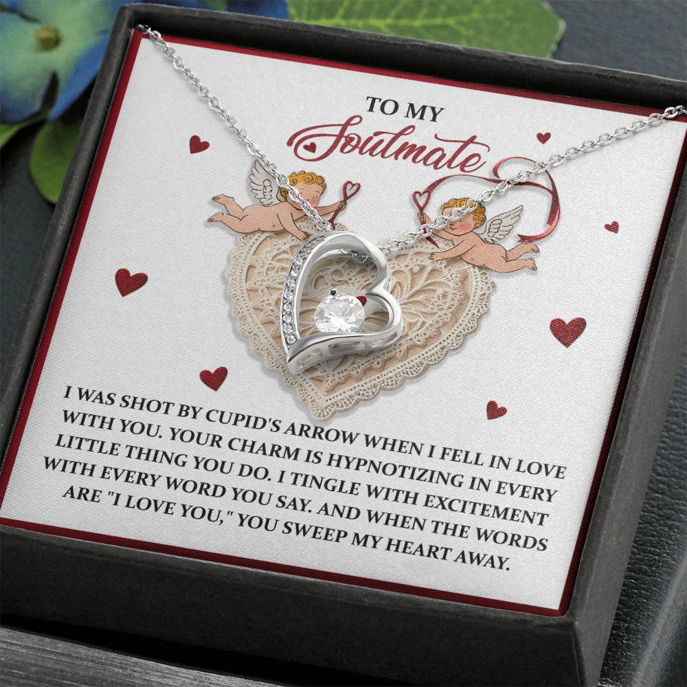 The Soulmate-Sweep My Heart - Forever Love Necklace is a stunning silver heart-shaped piece with a central CZ crystal, elegantly displayed on a card with cherubs and heart motifs. It comes in a sleek black box, ideal for cherishing an enduring bond.