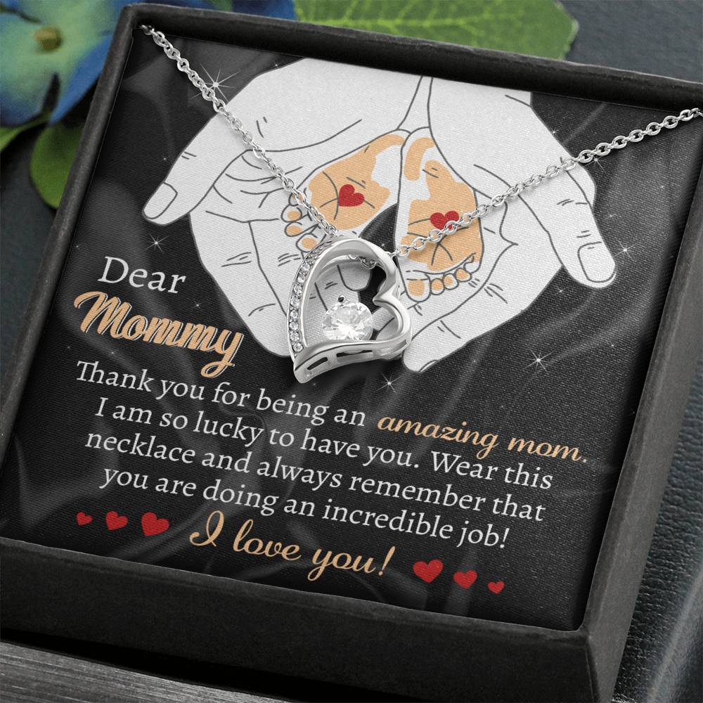 The white gold heart-shaped necklace, featuring a mother and child design, is beautifully displayed on a gift card that reads, "Dear Mommy, Thank you for being an amazing mom. I love you!" along with other heartfelt messages. This "To Mom To Be, An Incredible Job - Forever Love Necklace" is the perfect personalized gift to show your appreciation.