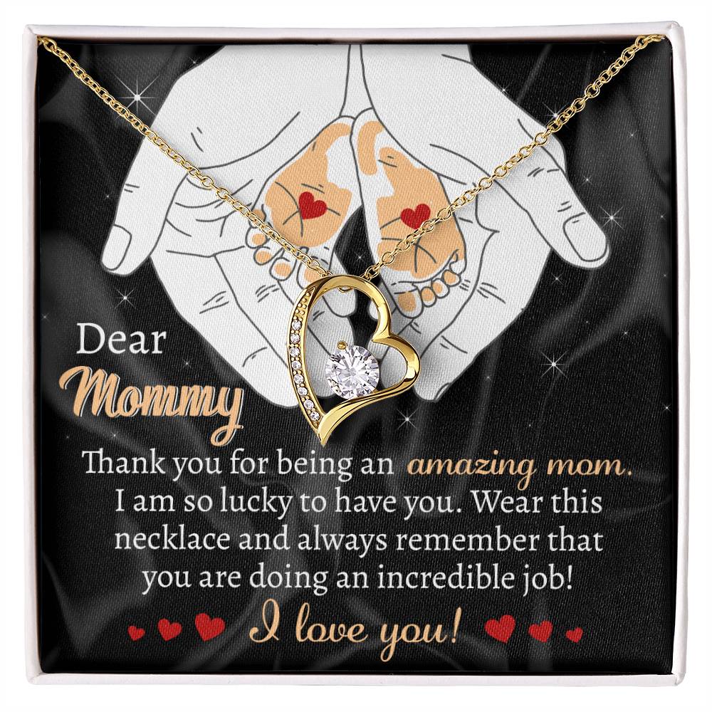 The "To Mom To Be, An Incredible Job - Forever Love Necklace" with a heart pendant is displayed in a box featuring a heartfelt message addressed to "Mommy," expressing love and appreciation. The backdrop includes an illustration of adult and baby hands holding hearts, making this personalized white gold gift truly special.