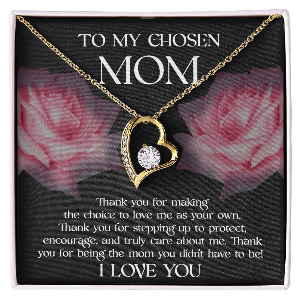 The 'To Bonus Mom, My Chosen Mom - Forever Love Necklace' features a heart-shaped pendant adorned with a gemstone and is displayed on a cushion surrounded by roses. It includes a heartfelt message expressing gratitude and love to your chosen mom. Available in either white gold or yellow gold finish, this piece makes an ideal Mother's Day gift.