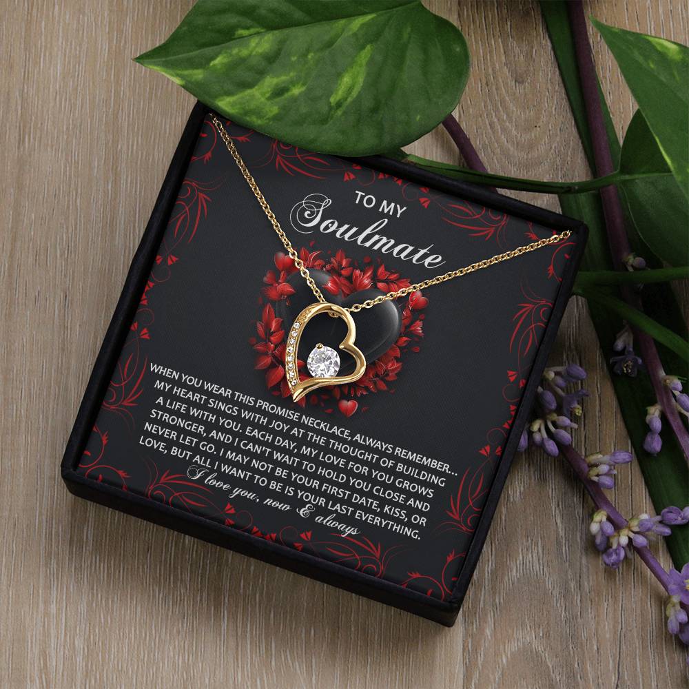 The Soulmate-Hold You Close - Forever Love Necklace has a gold-finished heart-shaped pendant with sparkling cubic zirconia and comes in a box with a decorative card background and floral accents.